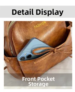 Vue détaillée de la poche avant du sac à dos en cuir marron avec nœud et rangement portable
