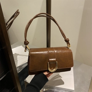 Sac à main vintage en cuir marron foncé avec boucle dorée et bandoulière à nœuds