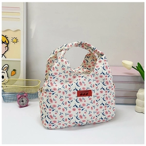 Close-up of floral bento bag with red leather brand tag and pink rose pattern