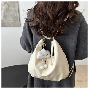 Detail of cream half-moon bag with cute cloud charm and embossed logo on fine PU leather
