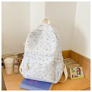 Detail of school backpack with blue star prints on a wooden desk with books