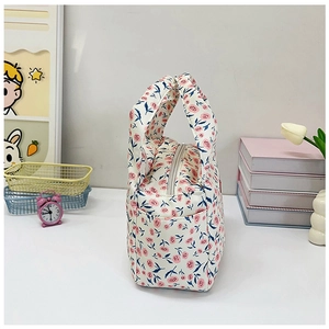 Detailed macro view of floral lunch bag with pink flowers and side pocket detail