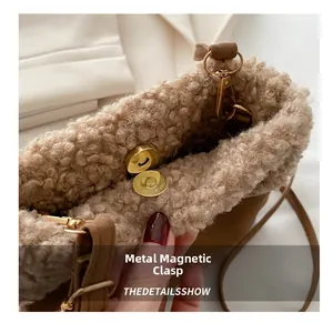 Detail view of the metal magnetic buckle closure on a brown fluffy fleece bucket bag