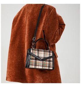Détail du sac à main vintage en laine à carreaux avec poignée en cuir et rabat en V épuré