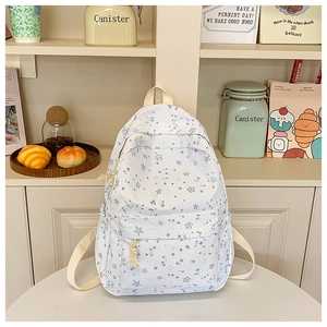 Detailed close-up of a white canvas star-patterned backpack with drawstring front pocket