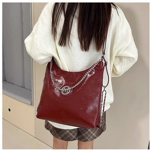 Détail du sac hobo bordeaux avec chaîne argentée et logo sur le modèle