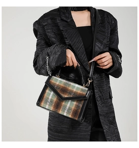 Mannequin portant un sac à bandoulière en tweed à carreaux avec détails dorés chic