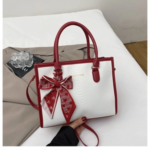 Dettaglio della borsa tote bicolore rosso e bianco con trama coccodrillo e foulard