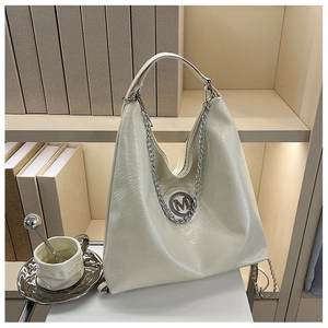 Détail du sac hobo blanc cassé montrant le cuir plissé et le logo métallique M argenté