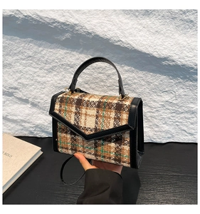 Détail du sac à main vintage en tweed à carreaux avec garniture en cuir noir et poignée
