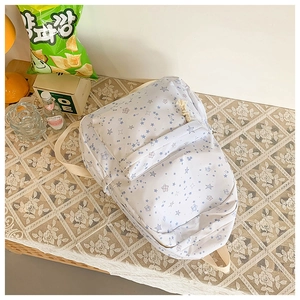 Detailed close-up of blue star printed backpack with rope zipper pulls and mesh straps