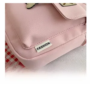 Detailed close-up of pink canvas fabric with a white Fashion label and fine stitching