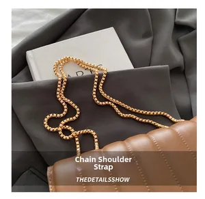 Detail of brown quilted leather bag featuring a sophisticated golden metal chain strap
