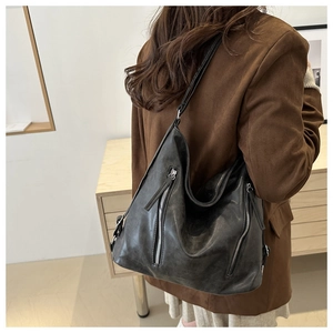 Dettaglio della borsa hobo vintage nera con cerniere argentate e finitura in ecopelle