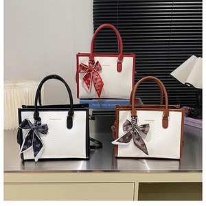 Trois sacs cabas élégants avec gaufrage serpent et foulards en soie chic sur les poignées