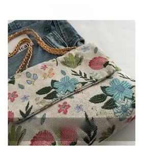 Detailed view of woven jacquard floral fabric and elegant gold chain strap
