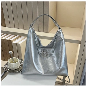 Gros plan sur un sac fourre-tout argenté métallisé avec texture froissée et logo M