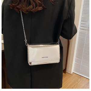 Sac bandoulière argenté brillant avec chaîne et logo Sunita Fashion sur le rabat