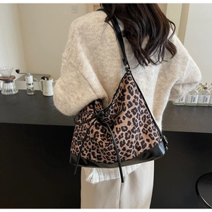 Fashionable leopard print shoulder bag with drawstring closure and leather patchwork detail
