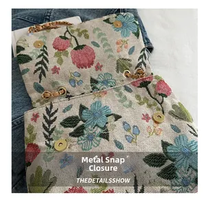Detail showing high-quality golden magnetic snaps and floral brocade fabric texture