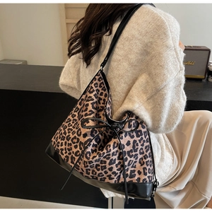 Detail of leopard print shoulder bag with black leather straps and a delicate bow knot