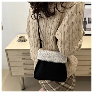 Detail of plush bucket bag featuring beige faux fur and black leather trim for women