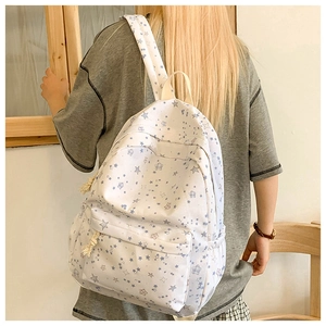 Detailed view of large white backpack with blue star prints and rope knot zippers