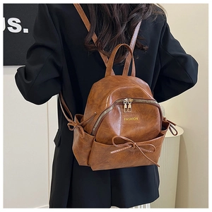 Gros plan d'un sac à dos en cuir PU marron avec nœud décoratif et fermeture éclair