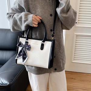 Borsa a mano quadrata bicolore bianco e nero con fiocco in seta e tracolla regolabile
