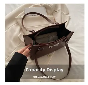 Top view of deep brown tote bag capacity showing cosmetics and wallet on beige blazer