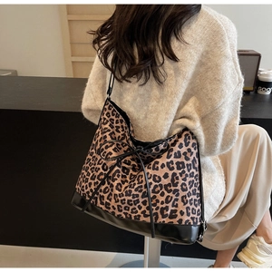 Macro detail of large leopard print tote bag with black decorative bow on canvas