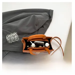 Internal view of brown leather handbag showing space for smartphone and skincare items