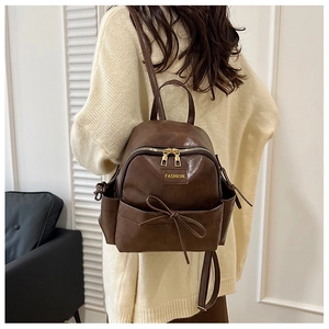 Mini sac à dos en cuir PU marron avec nœud papillon et étiquette porté par un mannequin