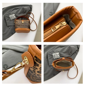 Detail view of leopard print bucket bag featuring brown leather trim and golden hardware