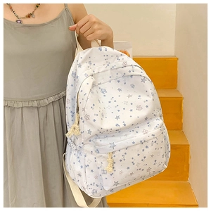 Side view of white canvas star print backpack with rustic rope zipper detail