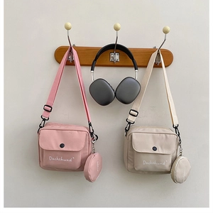 Detail showing canvas crossbody bags with matching round coin purses and adjustable straps