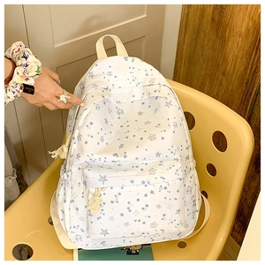 Detailed close-up of a white star-patterned backpack with dual zipper compartments
