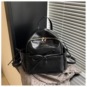 Vue détaillée du mini sac à dos noir en similicuir avec nœud et fermeture dorée