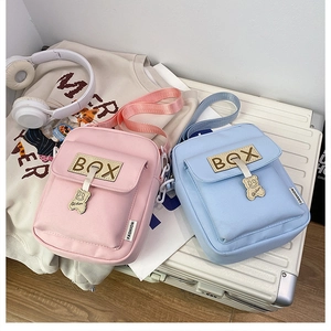 Detailed view of pastel pink and blue canvas messenger bags with cute bear zipper charms