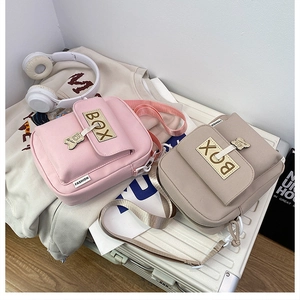 Close-up of small canvas crossbody bags in pink and beige with cute bear charms