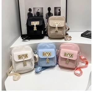 Detailed close-up of small canvas crossbody bags in five colors with bear metal pendants