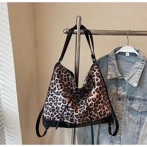 Close-up of leopard print shoulder bag with black leather base and decorative bow
