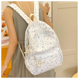 Detail of floral print school backpack showing main zipper and purple star pattern