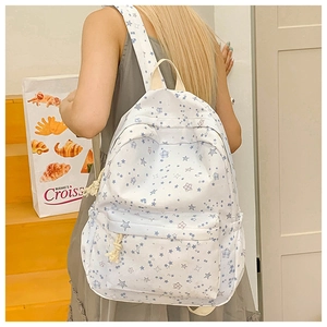 Student backpack with blue star prints shown from a back view on a model in daily use