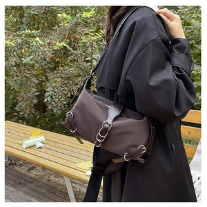 Détail du sac vintage marron avec anneaux métalliques argentés et garniture en cuir