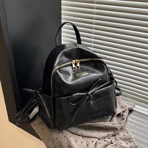 Sac à dos minimaliste en similicuir noir avec détails dorés et décoration nœud élégante