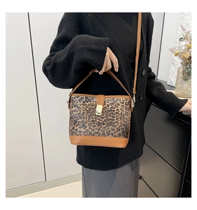 Detail view of leopard print bucket bag with gold hardware and stylish shoulder strap