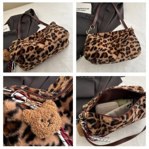 Vue détaillée du sac fourre-tout en fausse fourrure léopard avec bandoulière et pendentif ours
