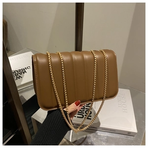 Detail of a brown quilted leather shoulder bag with a stylish gold chain strap