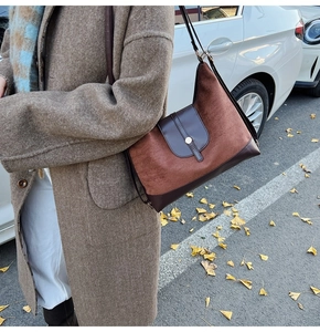 Detail view of retro tote bag in brown suede and leather texture for autumn look